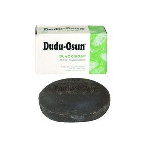 An African Black Soap Bar Alongside Its White and Green Packaging